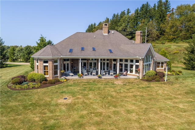 rear view of property featuring a lawn and a patio area