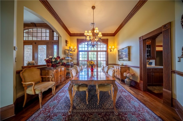 dining room with an inviting chandelier, dark wood-type flooring, and crown molding