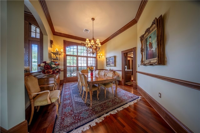 dining room featuring wood-type flooring, ornamental molding, and a notable chandelier