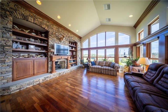 living room featuring wood-type flooring, a wealth of natural light, built in shelves, and a fireplace