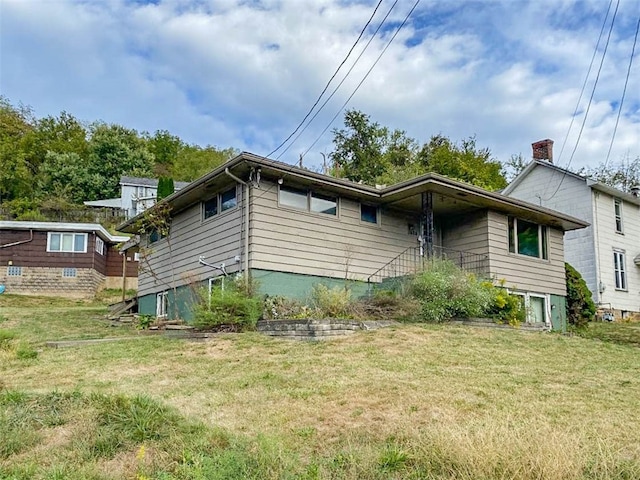 rear view of property featuring a lawn