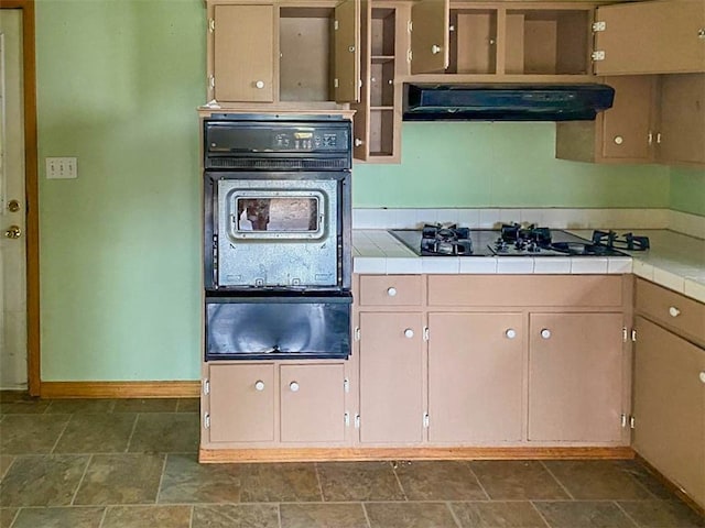 kitchen featuring ventilation hood, tile counters, and black appliances