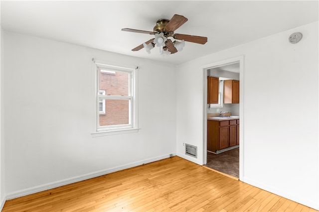 interior space featuring ceiling fan, light wood-type flooring, and sink