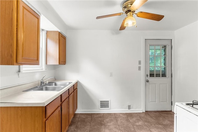 1099 George St, Sharon, PA 16146 - kitchen featuring a sink, light countertops, baseboards, light tile patterned floors, and brown cabinetry