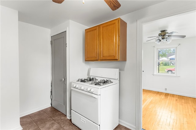 kitchen featuring ceiling fan, hardwood / wood-style flooring, and white gas range oven