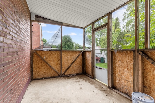 unfurnished sunroom featuring lofted ceiling and plenty of natural light