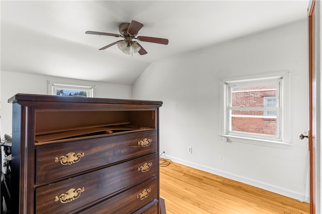 bedroom featuring ceiling fan, light wood-type flooring, and vaulted ceiling