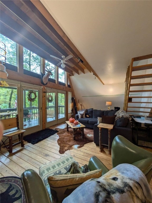 living area with wood-type flooring, a healthy amount of sunlight, vaulted ceiling with beams, and ceiling fan