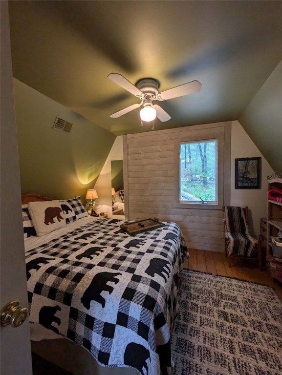 bedroom with ceiling fan, lofted ceiling, and hardwood / wood-style floors