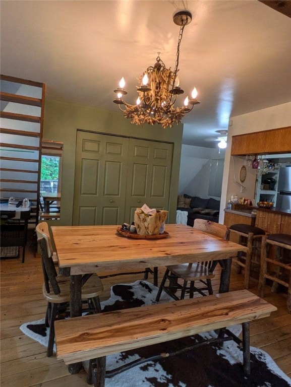 dining space with hardwood / wood-style floors and a chandelier