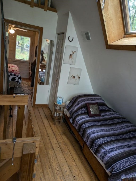 bedroom with a closet, wood-type flooring, and a skylight