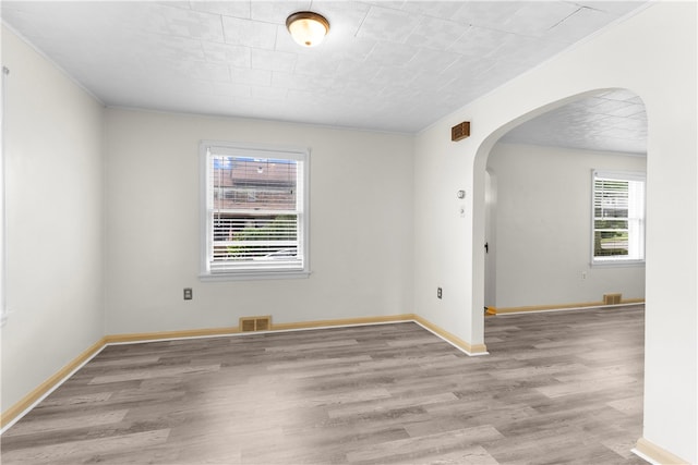 unfurnished room featuring ornamental molding and light hardwood / wood-style floors