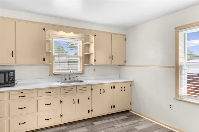 kitchen featuring light wood-type flooring, cream cabinetry, and sink