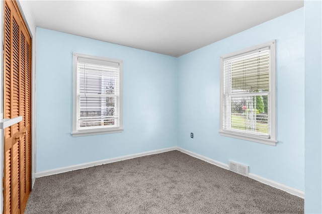 unfurnished bedroom featuring a closet, carpet, and multiple windows