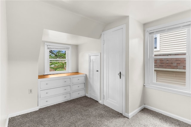 unfurnished bedroom featuring lofted ceiling and carpet flooring