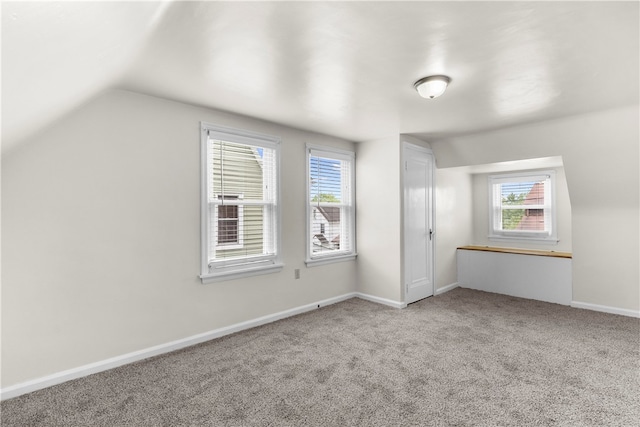 additional living space featuring lofted ceiling and carpet flooring