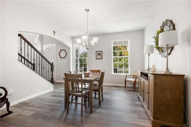 dining space featuring dark hardwood / wood-style flooring and an inviting chandelier