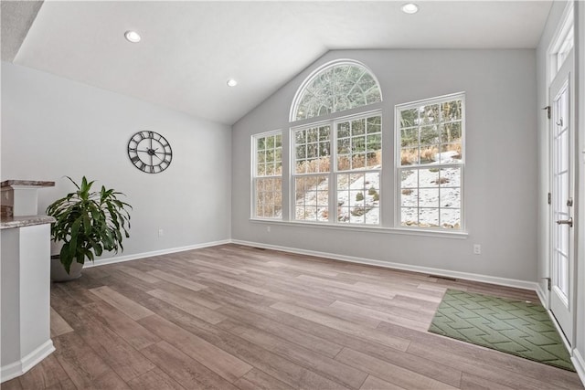 unfurnished dining area with light hardwood / wood-style flooring and lofted ceiling