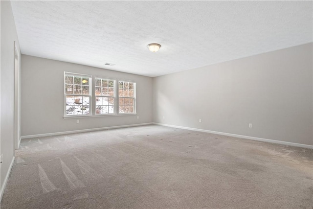 empty room featuring carpet and a textured ceiling