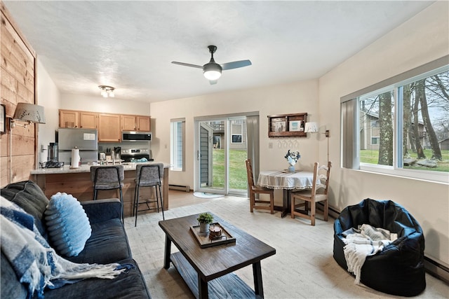 carpeted living room featuring ceiling fan and a baseboard radiator