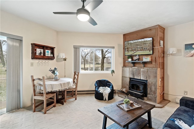 carpeted living room with ceiling fan and a tile fireplace