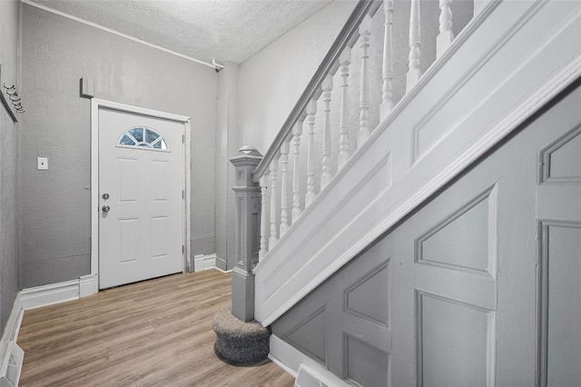 foyer featuring a textured ceiling and light hardwood / wood-style floors