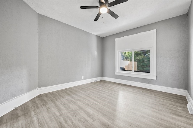 empty room with ceiling fan and light hardwood / wood-style floors