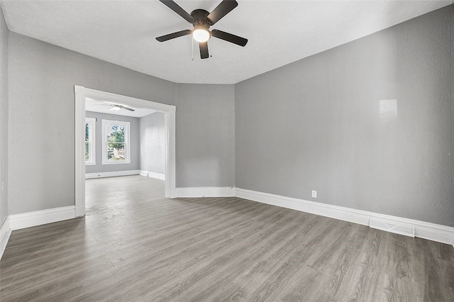 empty room featuring a textured ceiling, wood-type flooring, and ceiling fan