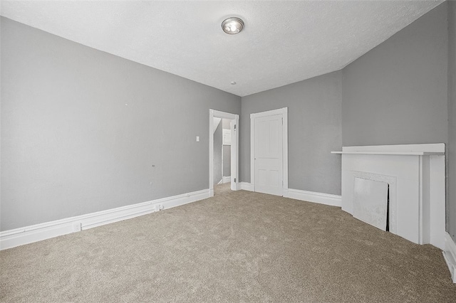 unfurnished living room with carpet flooring, a textured ceiling, and a fireplace