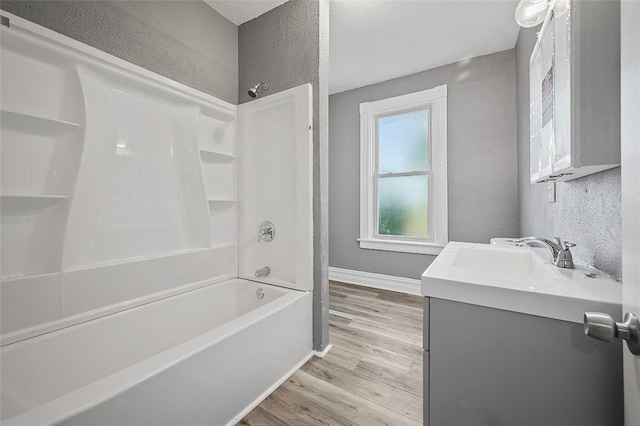 bathroom featuring vanity, a textured ceiling, hardwood / wood-style floors, and shower / washtub combination