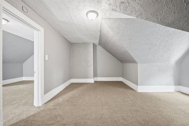 bonus room with lofted ceiling, carpet, and a textured ceiling