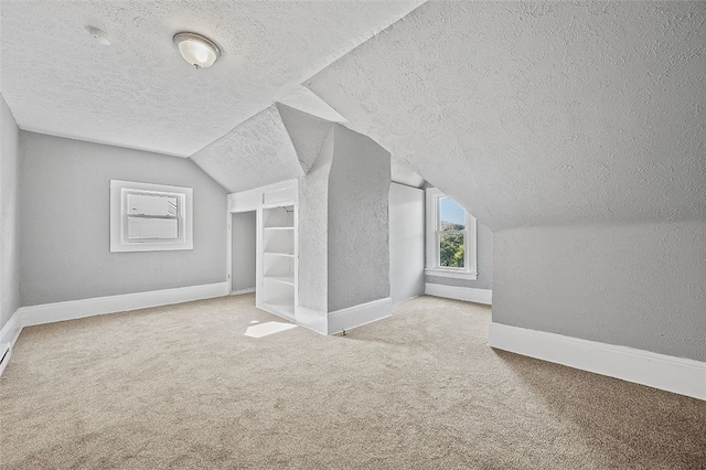 bonus room with carpet floors, a textured ceiling, and vaulted ceiling