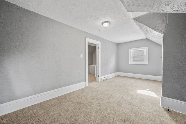 additional living space with vaulted ceiling, a textured ceiling, and carpet flooring