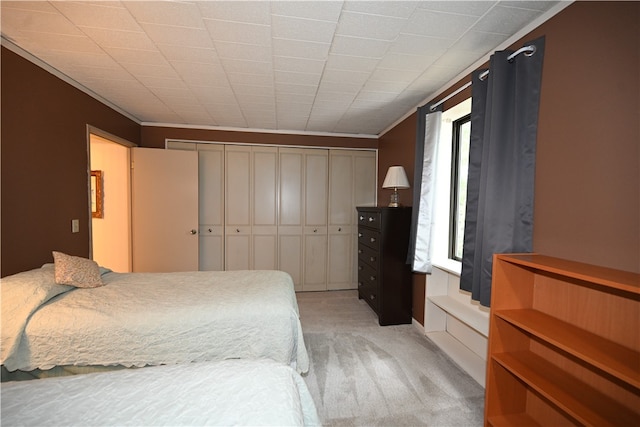 carpeted bedroom with ornamental molding and a closet