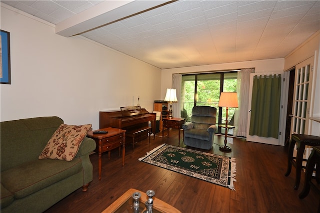 living room featuring beamed ceiling and dark hardwood / wood-style flooring