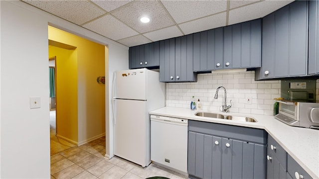 kitchen featuring light tile patterned flooring, tasteful backsplash, white appliances, a paneled ceiling, and sink