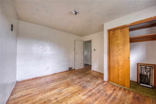 unfurnished bedroom with a closet and hardwood / wood-style floors