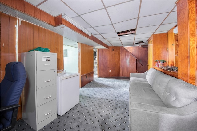 interior space featuring light colored carpet, wood walls, and a paneled ceiling