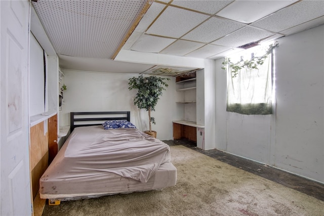 bedroom featuring a paneled ceiling and concrete floors