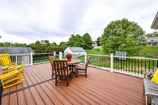 wooden deck featuring a lawn and a storage shed