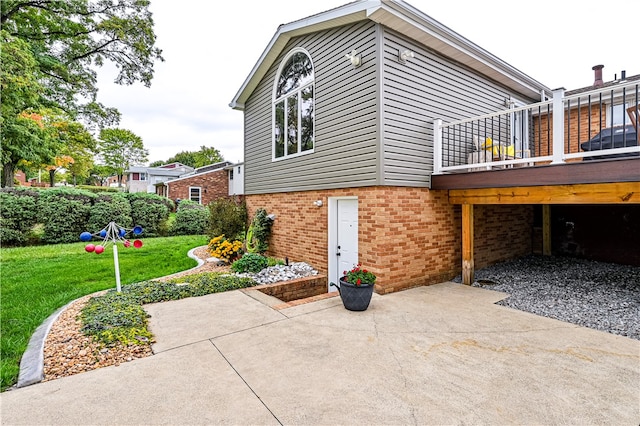 view of property exterior with a patio, a deck, and a yard