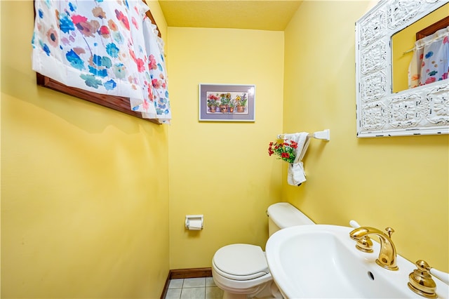 bathroom featuring a textured ceiling, tile patterned flooring, toilet, and sink