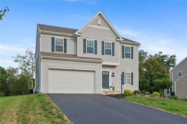 view of front of house featuring cooling unit, a garage, and a front lawn