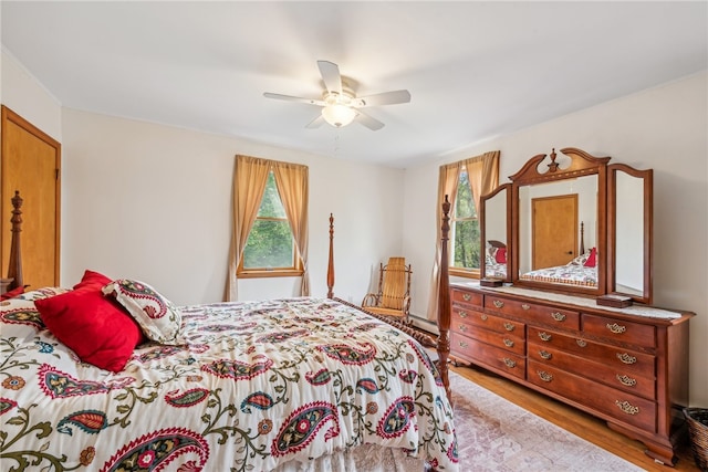 bedroom with a baseboard heating unit, light hardwood / wood-style floors, and ceiling fan