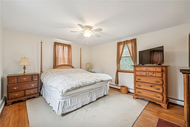 bedroom featuring a baseboard heating unit, wood-type flooring, and ceiling fan