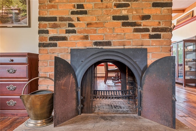 details with a wood stove and hardwood / wood-style flooring