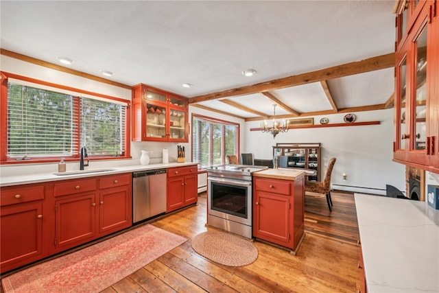 kitchen featuring light wood-type flooring, sink, a notable chandelier, a kitchen island, and appliances with stainless steel finishes