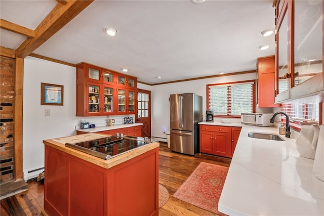 kitchen featuring stainless steel fridge, sink, baseboard heating, a center island, and dark hardwood / wood-style flooring