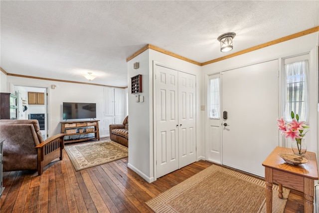 entryway featuring wood-type flooring, a textured ceiling, and crown molding