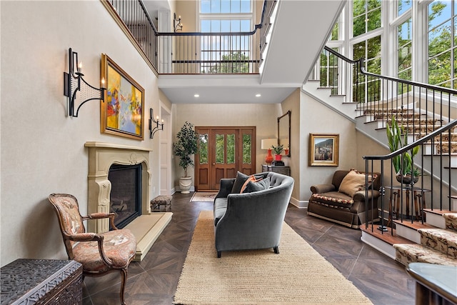 living room featuring a wealth of natural light, dark parquet floors, and a high ceiling